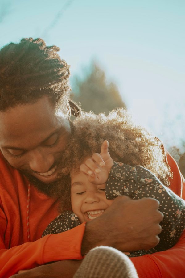 Father hugging his laughing daughter